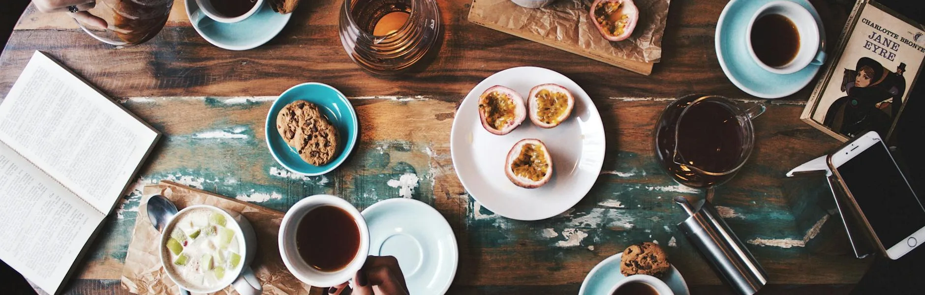 person sitting near table with teacups and plates